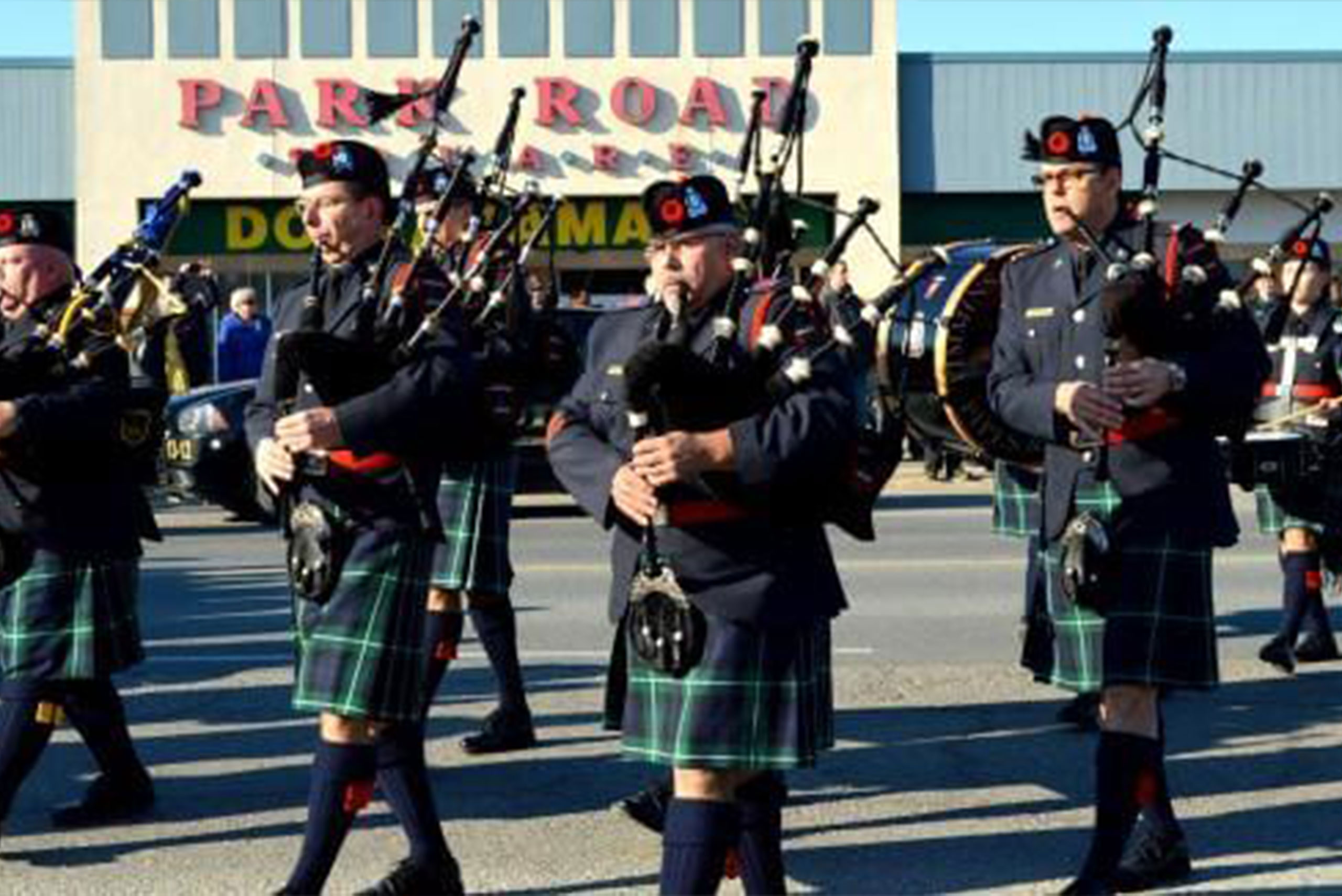 Timmins Police Men in kilts marching down the street with bagpipes during the Timmins Ontario Police event.